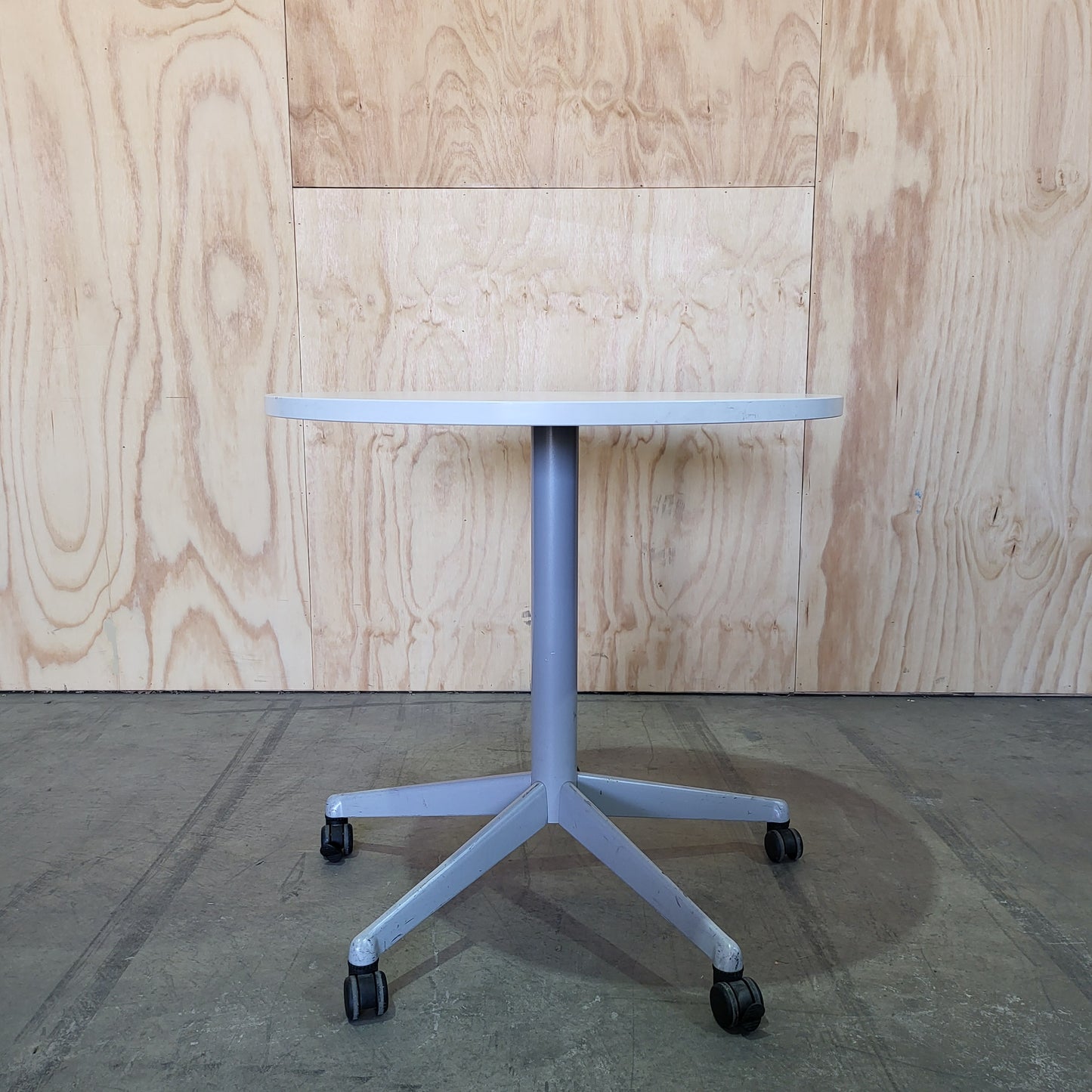 Round white table on 5 star castors